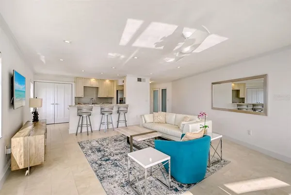 a living room with furniture and a dining table with kitchen view