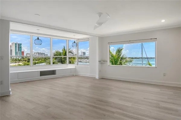 an empty room with wooden floor and outdoor view