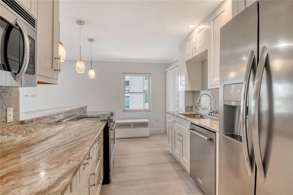 660 Golden Gate Point, Unit 32 Sarasota, FL 34236 - Photo 20 of 52 a kitchen with stainless steel appliances granite countertop a sink a stove and a refrigerator