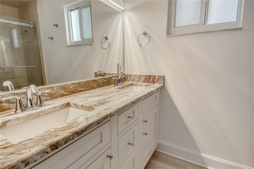 660 Golden Gate Point, Unit 32 Sarasota, FL 34236 - Photo 24 of 52 a bathroom with a granite countertop sink and a mirror