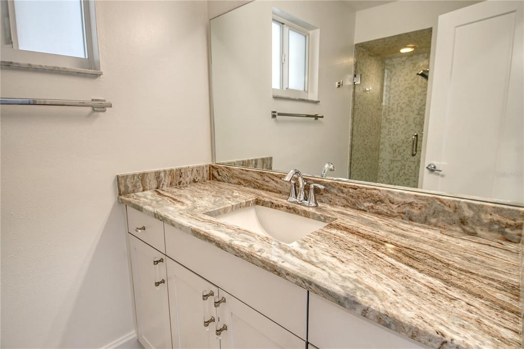 660 Golden Gate Point, Unit 32 Sarasota, FL 34236 - Photo 29 of 52 a bathroom with a granite countertop sink and a mirror