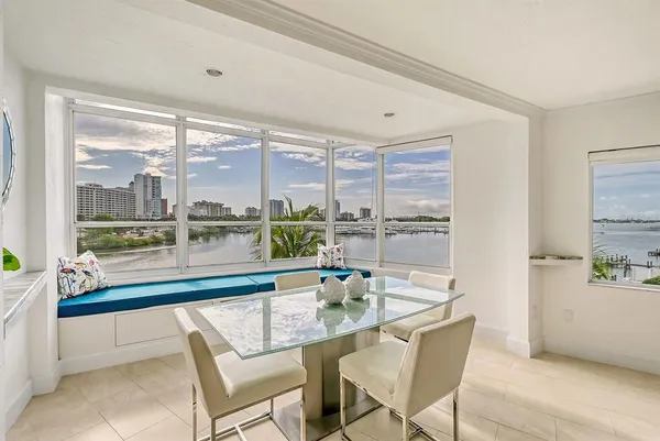 a dining room with furniture and a floor to ceiling window