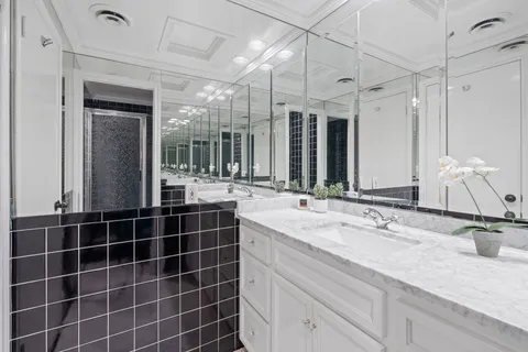 a bathroom with a double vanity sink mirror and shower