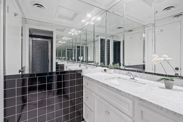 a bathroom with a double vanity sink mirror and shower