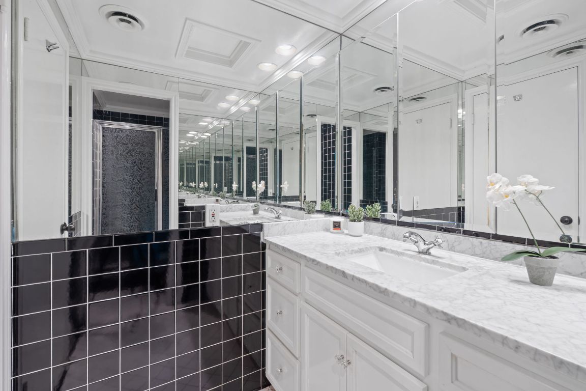 1801 Lavaca Street, Unit 12K Austin, TX 78701 - Photo 16 of 27 a bathroom with a double vanity sink mirror and shower
