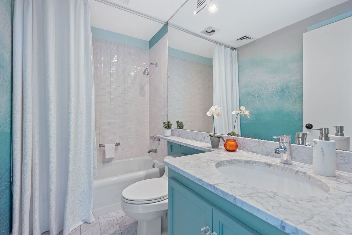 1801 Lavaca Street, Unit 12K Austin, TX 78701 - Photo 17 of 27 a bathroom with a sink toilet and shower