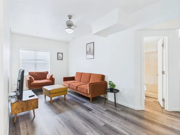a living room with furniture and a wooden floor