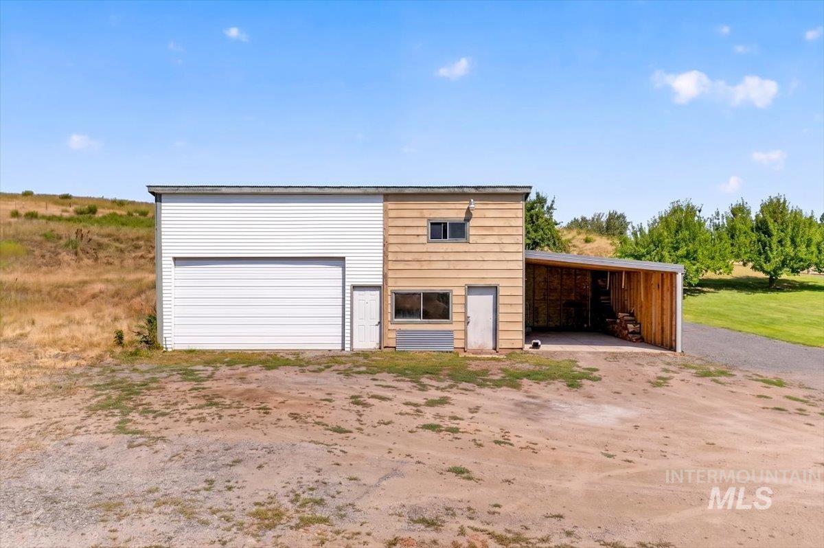 1071 Reynolds Road Princeton, ID 83857 - Photo 12 of 12 Multi-purpose outbuilding featuring a large roll-up door, a separate pedestrian entry, and a covered lean-to structure