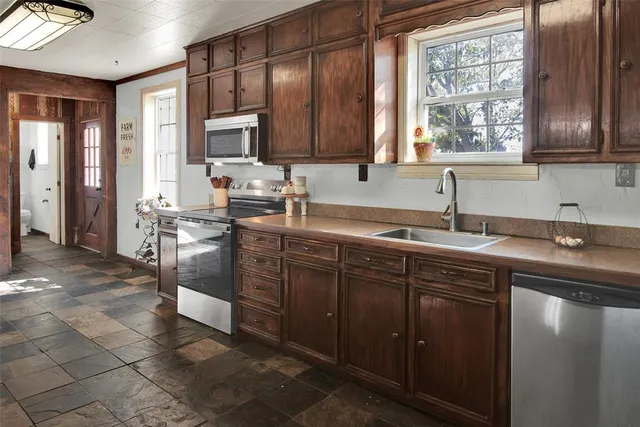 a kitchen with stainless steel appliances granite countertop a sink stove and cabinets