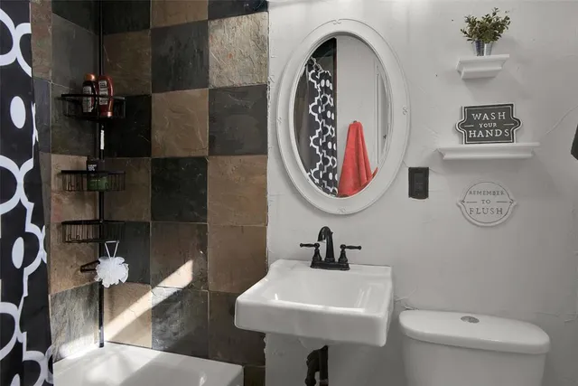 a bathroom with a toilet sink and mirror