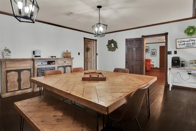 a dining table with a chandelier and wooden floor