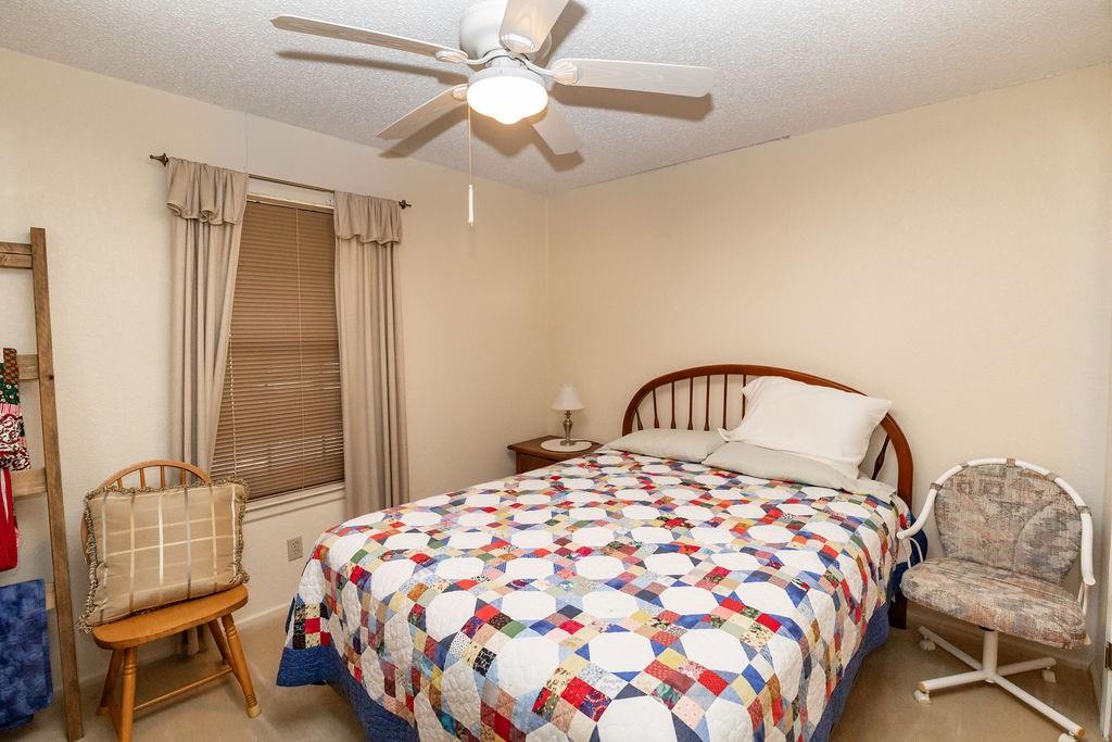 471 Hcr 3335 Road Hubbard, TX 76648 - Photo 23 of 40 a bedroom with a bed and a chandelier