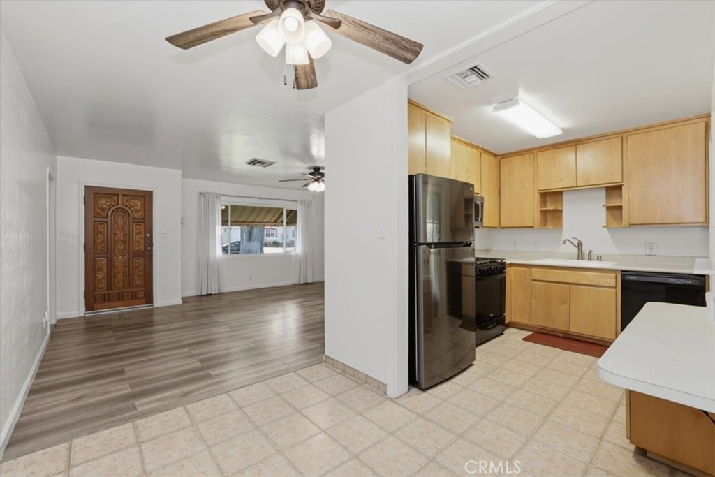 7869 Sycamore Avenue Riverside, CA 92504 - Photo 17 of 36 a kitchen with stainless steel appliances granite countertop a refrigerator a sink dishwasher a stove with white cabinets and wooden floor