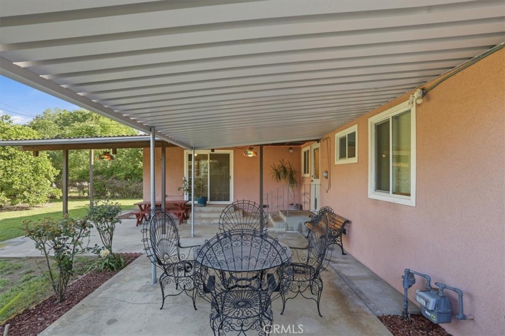 7869 Sycamore Avenue Riverside, CA 92504 - Photo 26 of 36 a view of a patio with table and chairs potted plants and floor to ceiling window