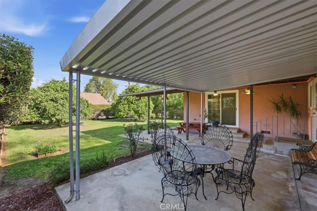 7869 Sycamore Avenue Riverside, CA 92504 - Photo 27 of 36 a view of a patio with table and chairs and floor to ceiling window with plants