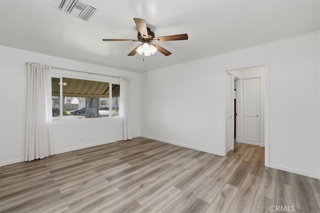 7869 Sycamore Avenue Riverside, CA 92504 - Photo 8 of 36 a view of an empty room with wooden floor and a window