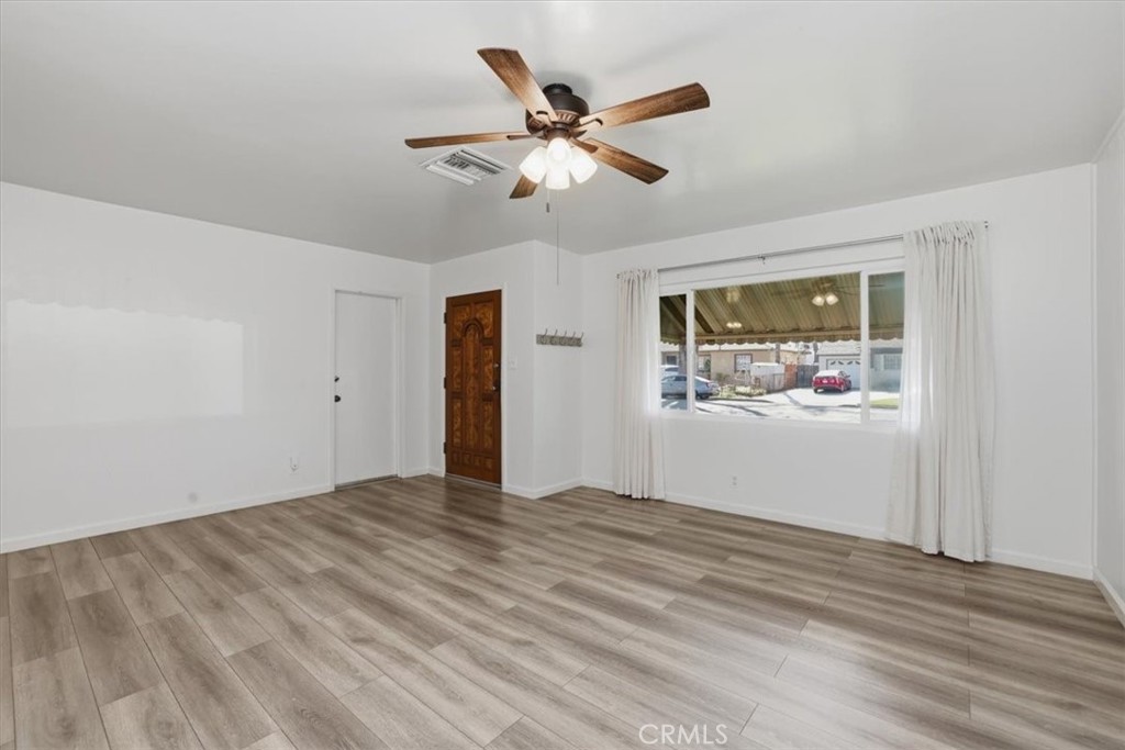 7869 Sycamore Avenue Riverside, CA 92504 - Photo 9 of 36 a view of an empty room with wooden floor and a ceiling fan