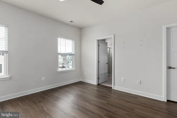 an empty room with wooden floor and window