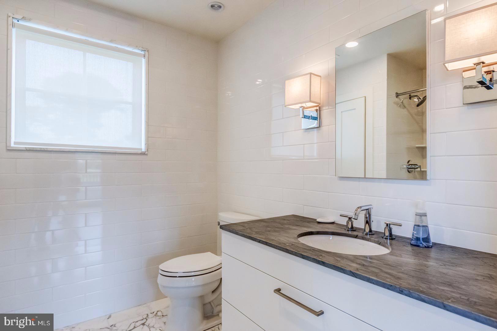 609 St Andrews Road Philadelphia, PA 19118 - Photo 23 of 31 a bathroom with a granite countertop sink and a toilet