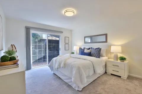 a large bed sitting in a bedroom next to a window