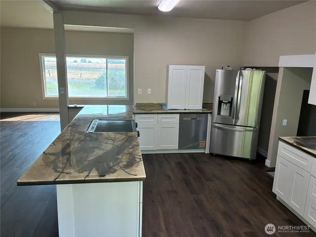 a kitchen with wooden floor and stainless steel appliances