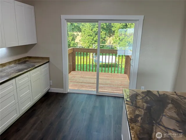 a view of a bedroom with wooden floor and a window