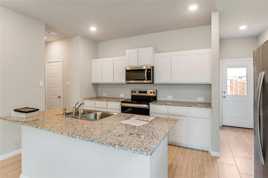3137 Pecan Farm Lane Fort Worth, TX 76140 - Photo 19 of 31 a kitchen with granite countertop a sink and a stove top oven