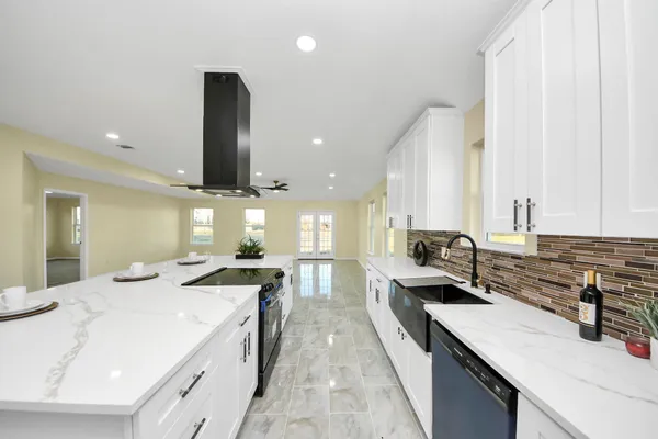 a large kitchen with stainless steel appliances lots of counter space and a sink