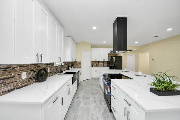 a kitchen with stainless steel appliances a sink a stove top oven a counter space and cabinets