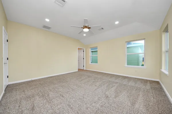 an empty room with windows and fan