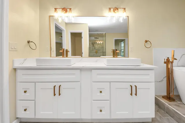 a spacious bathroom with a tub sink and mirror