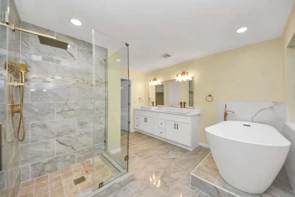 a bathroom with a tub sink and mirror