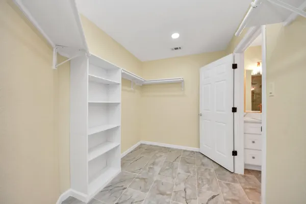a view of walk in closet with white walls