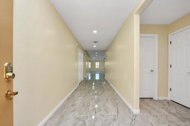 a view of hallway with a bathroom