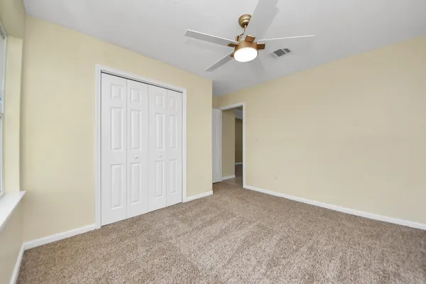an empty room with a ceiling fan and a window