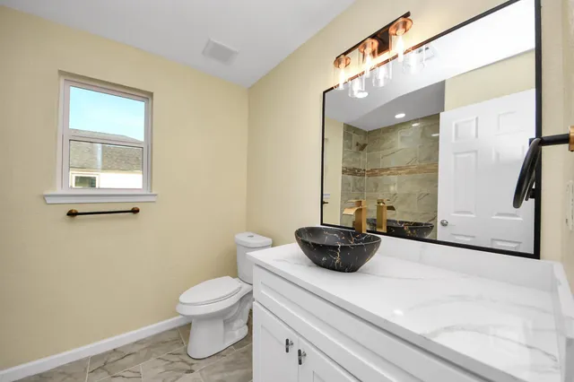 a bathroom with a toilet a sink and mirror