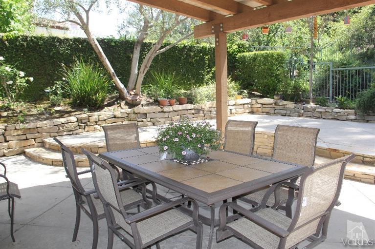 11212 Terraceridge Road Moorpark, CA 93021 - Photo 22 of 26 a view of a patio with table and chairs potted plants and palm tree