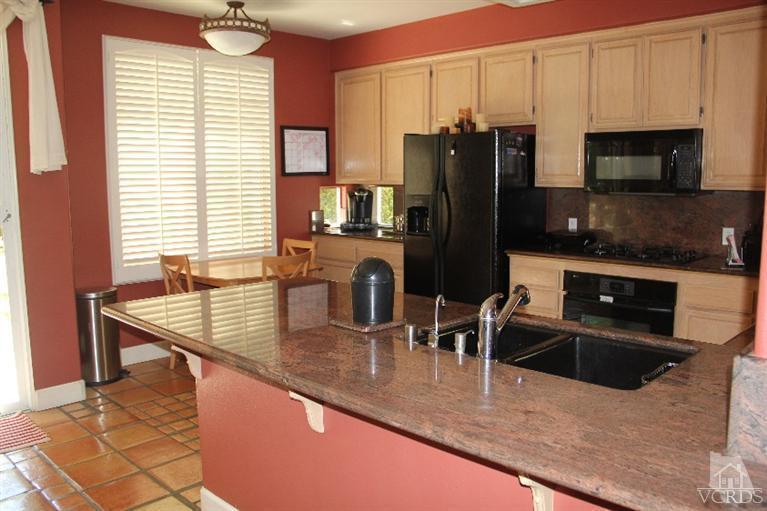 11212 Terraceridge Road Moorpark, CA 93021 - Photo 4 of 26 a kitchen with stainless steel appliances granite countertop a sink a stove and a microwave