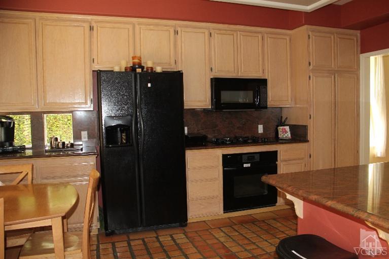 11212 Terraceridge Road Moorpark, CA 93021 - Photo 6 of 26 a kitchen with stainless steel appliances granite countertop a refrigerator a stove and a sink with wooden cabinets