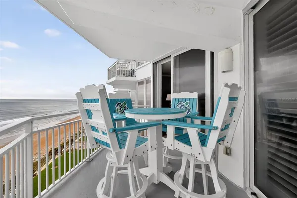 a view of a chairs and table in the balcony