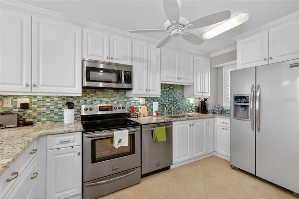 a kitchen with stainless steel appliances kitchen island granite countertop a sink counter space cabinets and a stove