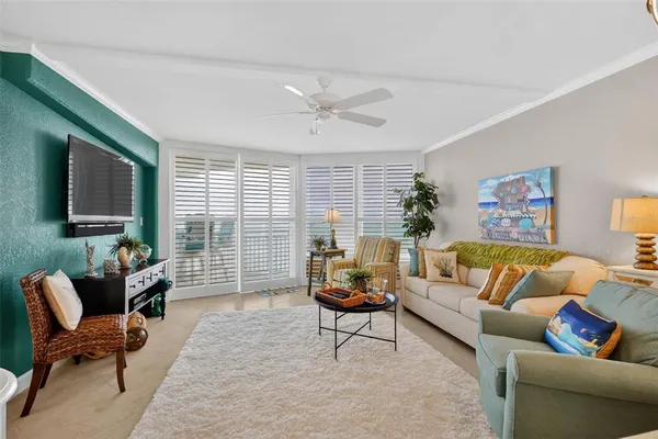 a living room with furniture a chandelier and a flat screen tv