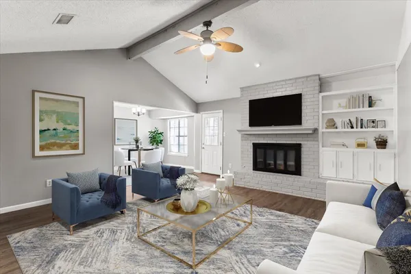 a living room with furniture a fireplace and a flat screen tv