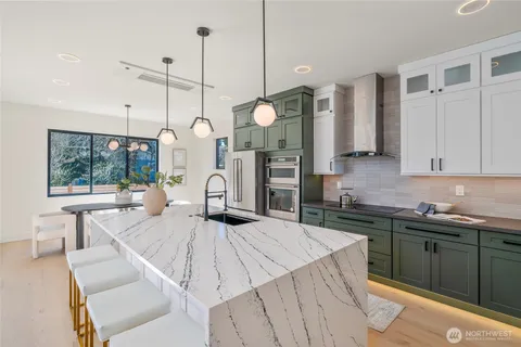 a large kitchen with kitchen island a sink a counter space and stainless steel appliances