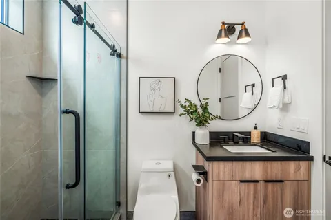 a bathroom with a granite countertop sink a toilet and shower