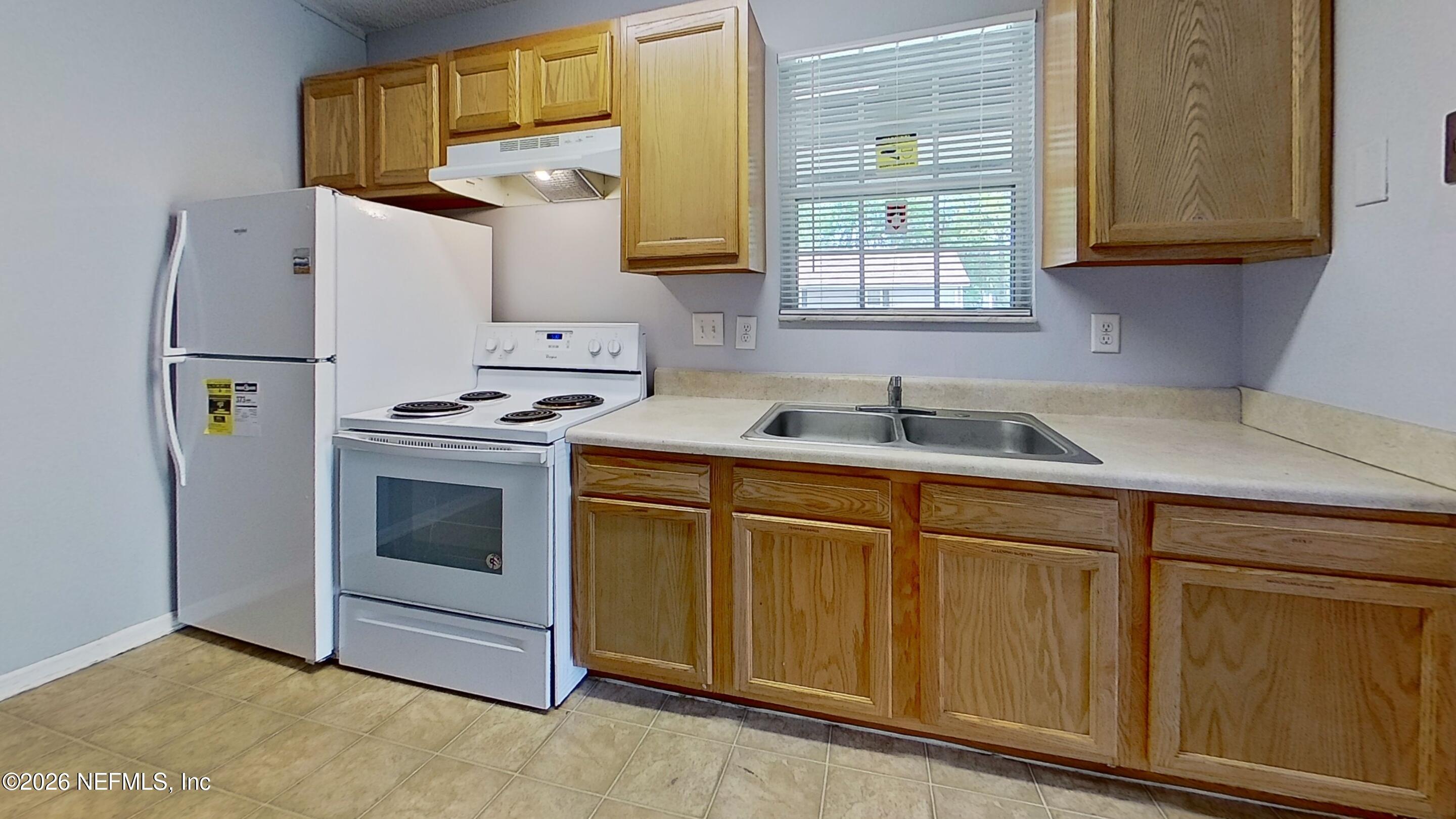 1130 Comanche Street, Unit 401 Jacksonville, FL 32205 - Photo 5 of 9 a kitchen with stainless steel appliances granite countertop a sink and a refrigerator
