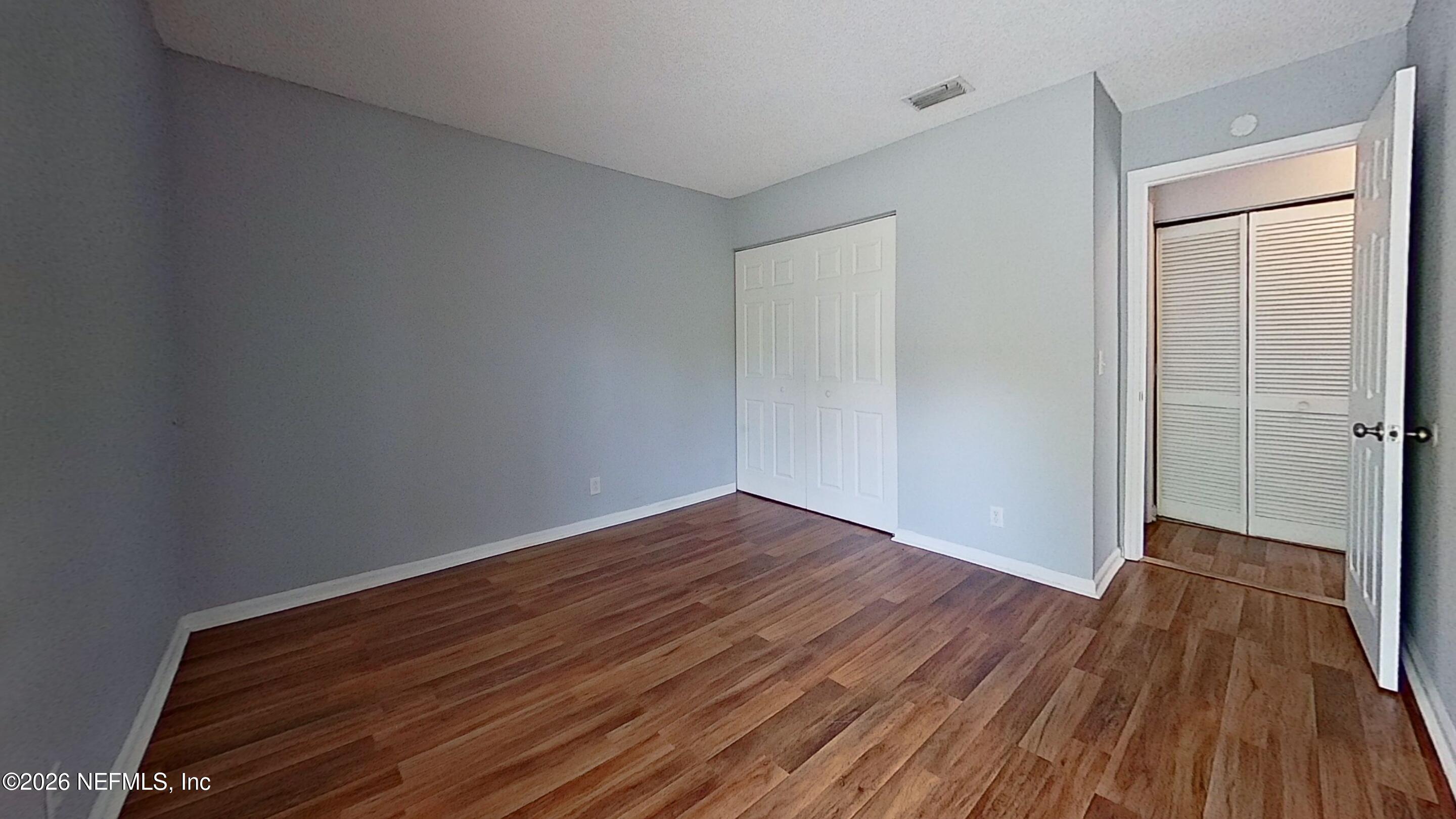 1130 Comanche Street, Unit 401 Jacksonville, FL 32205 - Photo 8 of 9 a view of an empty room with wooden floor and a window