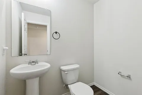 a bathroom with a toilet sink and mirror