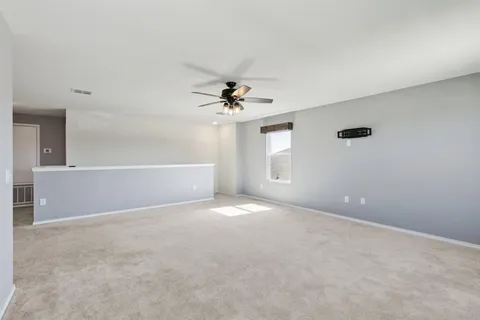 a view of a livingroom with a ceiling fan and window