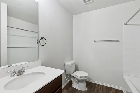 a bathroom with a toilet a sink and mirror